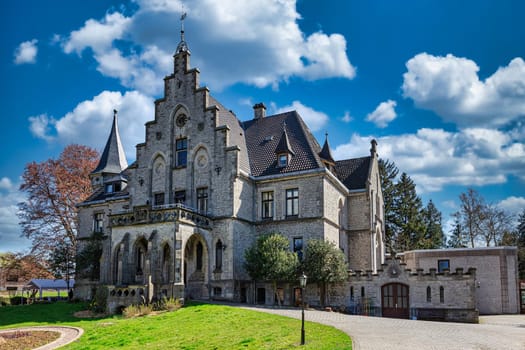 The Gestorf castle in the spring against the background of the sky with clouds.