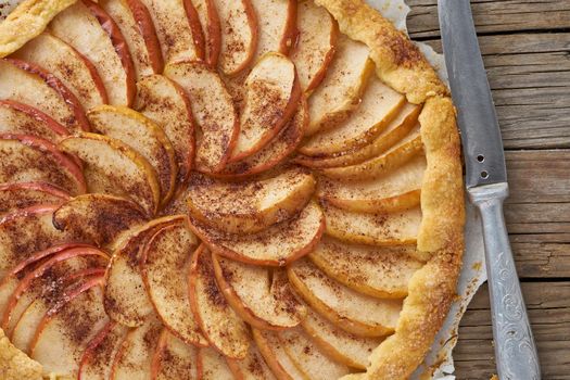 Apple pie, galette with fruits, sweet pastries on old wooden rustic table. Close up.