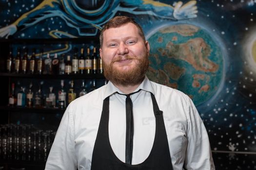 Bearded Adult Funny Positive Smiling Caucasian Looking Professional Bartender Portrait in Nightclub.