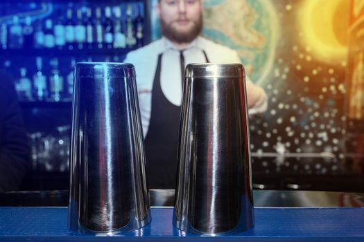 Shaker bar instrument for mixing and preparing alcoholic cocktails and drinks in front of a bartender in a nightclub.