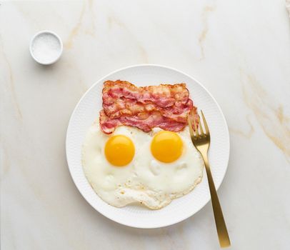 fried eggs with bacon, foodmap ketogenic keto diet, top view, background fork and salt