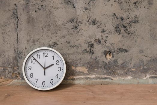 clock wooden desk against weathered wall