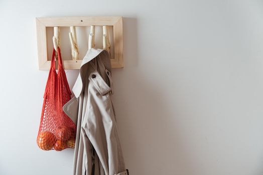 straw bag and trench on handmade wooden hang. Concept of slowlife home. High quality photo