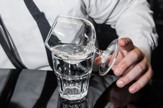 The process of preparing an alcoholic hot cocktail with Italian liqueur of a drink in sambuca glass.