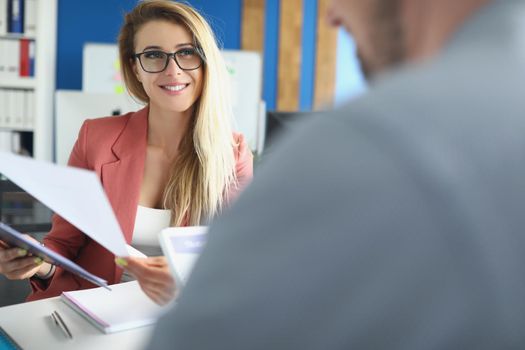 Portrait of optimistic woman discuss business papers with colleague, lady boss. Woman happy about company results. Business, career growth, success concept