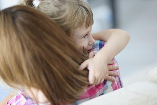 Portrait of mother and daughter hugging, mother comfort little kid, warm precious family moment. Kid spend time with parent. Family relationship concept