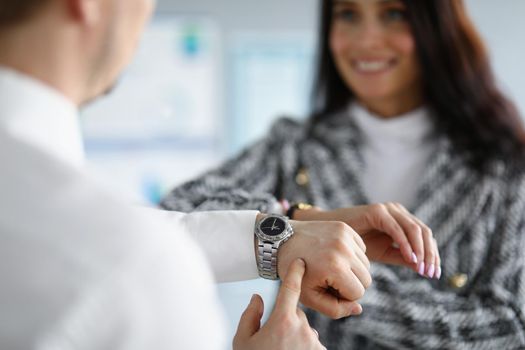 Portrait of businesspeople comparing time on wristwatches, coworkers check if time right on dial. Timing, late, on time, office life, watch time concept