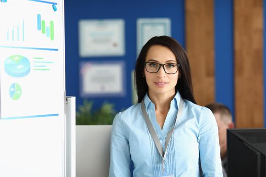 Portrait of confident young businesswoman in corporation office, wearing glasses. Conference participant, team leader, specialist. Business, career concept