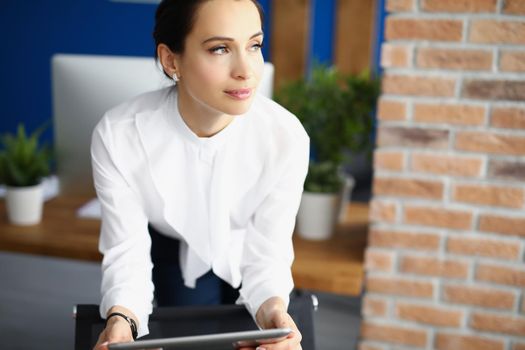 Portrait of clever business lady use digital tablet device to plan meetings. Pretty clerk in black and white outfit work in big company. Business concept