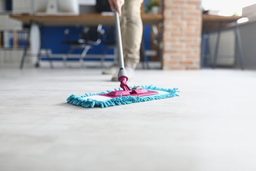 Close-up of person wiping floor with fluffy mop, domestic work, housewife cleaning at home. Cleaning routine, household chores, cleaning service concept