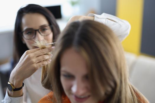 Portrait of friend cutting hair with scissors tool, ask friend to help with image change. Wellness, beauty day, friendship, experiment, fun, bff concept