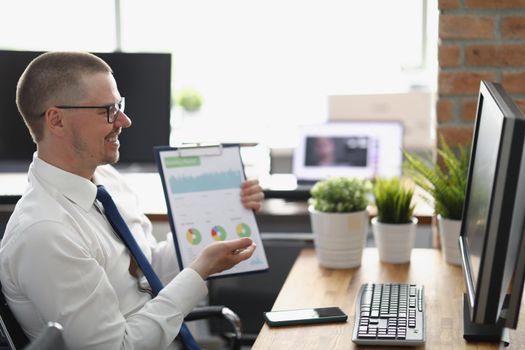 Portrait of businessman presenting financial report online to colleague, clever middle aged clerk in suit. Desktop computer on table. Business, job concept