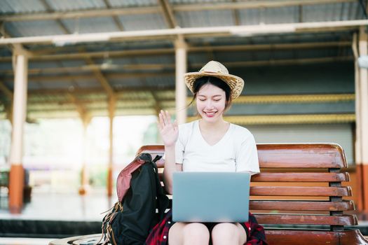 summer, relax, vacation, travel, portrait of beautiful Asian girl using the computer laptop at the train station while waiting for their travel time