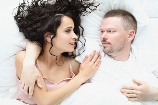 Portrait of lovely couple hugging in bed in morning, well rested family enjoying staying in bed. Lazy weekend, chilling together. Good morning concept