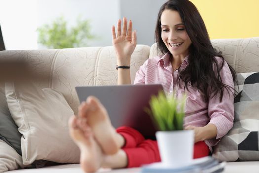 Portrait of woman wave hello, talk to friend via video call, happy to hear you. Talk to family from home, good connection. Technology, greeting concept