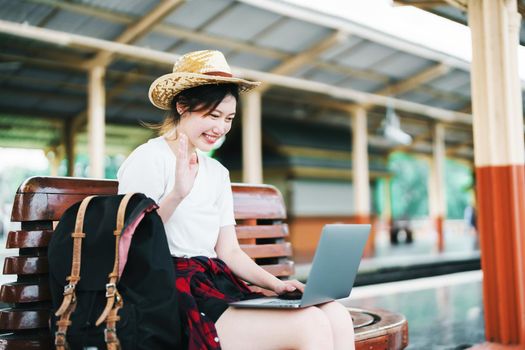 summer, relax, vacation, travel, portrait of beautiful Asian girl using the computer laptop at the train station while waiting for their travel time