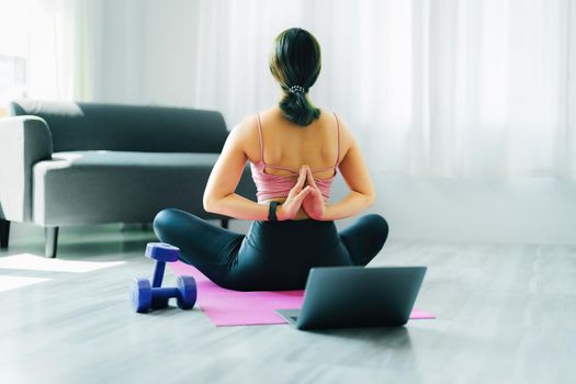 stress relief, muscle relaxation, breathing exercises, exercise, meditation, portrait of Young Asian woman relaxing her body from office work by practicing yoga by watching online tutorials