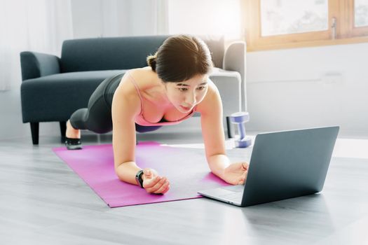 stress relief, muscle relaxation, breathing exercises, exercise, meditation, portrait of Young Asian woman relaxing her body from office work by practicing yoga by watching online tutorials