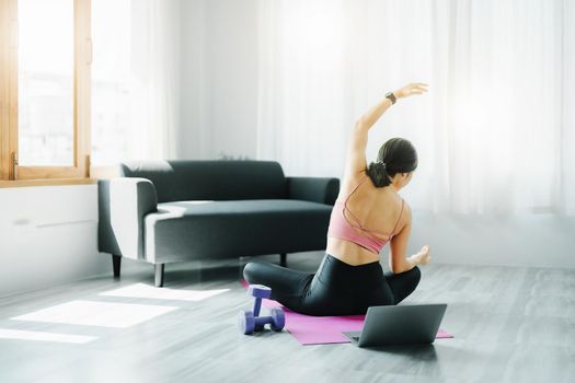 stress relief, muscle relaxation, breathing exercises, exercise, meditation, portrait of Young Asian woman relaxing her body from office work by practicing yoga by watching online tutorials