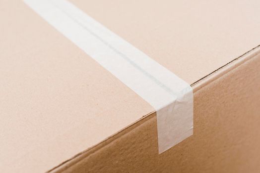 overhead view cardboard box sealed with white packing tape