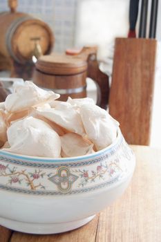 Meringue cookies in a vase on a wooden cutting board. still life