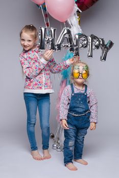 the child in the arms of his mother on a white background. A woman with a child in her arms holding festive balloons