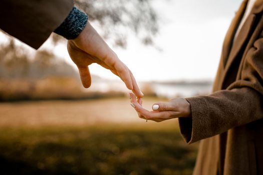 close up couple holding hands outdoors