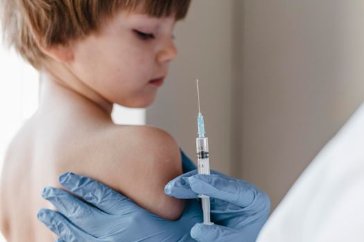 doctor with gloves performing vaccine little child