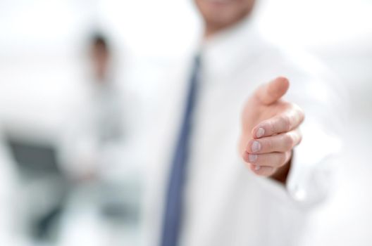 blurred image. business man holding out his hand for a handshake.business background
