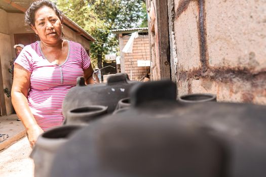 Artisan checking clay pots drying in the sun in a craft workshop in La Paz Centro, Nicaragua. Concept of travel, culture and economy in poor countries of Latin America.