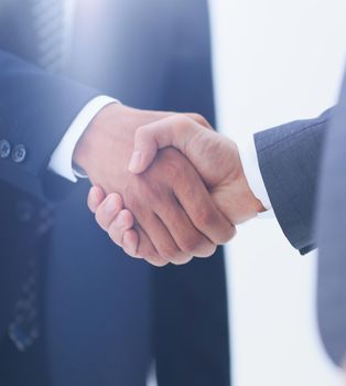 Two young businessman standing opposite each other and shake their hands.