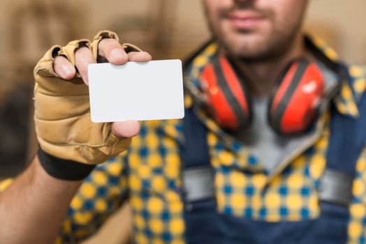 male carpenter showing blank white visiting card