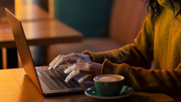 sideways woman working her laptop coffee shop