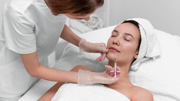 beautician doing injection filler female client