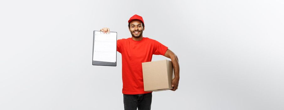 Delivery Concept - Portrait of Handsome African American delivery man or courier showing a confirmation document form to sign. Isolated on Grey studio Background. Copy Space