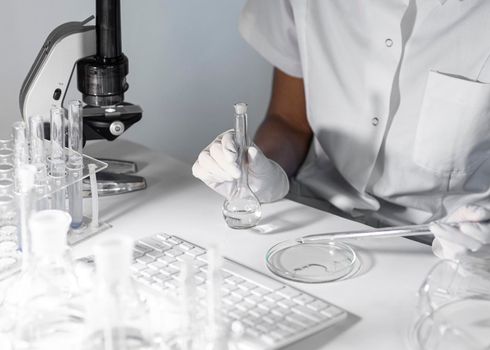 close up scientist holding glassware