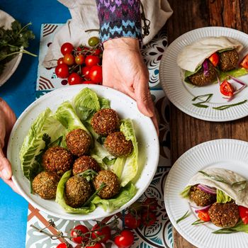 close up hands holding plate with jewish food