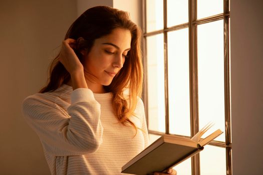 side view young woman reading book home