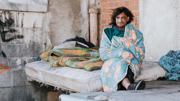 front view homeless man mattress outside blanket