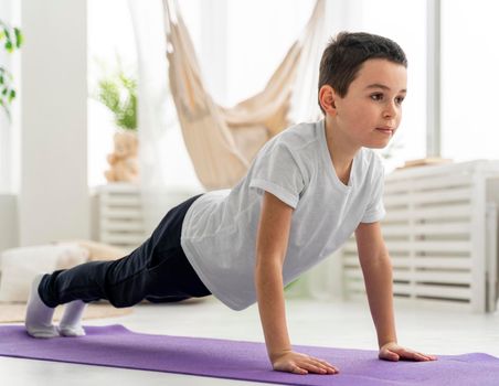 full shot kid doing plank