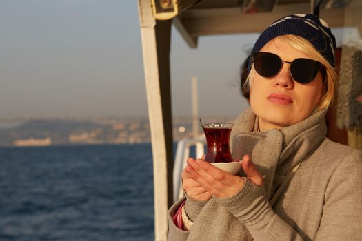 Young woman drinking traditional Turkish tea in Instanbul.