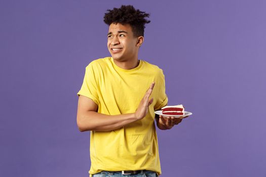 Celebration, party and holidays concept. Oh gosh its disgusting. Portrait of reluctant and displeased young man turn away from awful bad taste cake, show refusal, rejection or stop sign.
