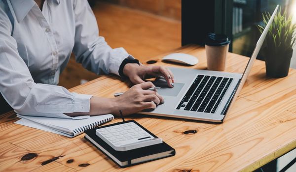 Business woman using calculator with laptop computer, Business accounting, budget and loan from marketing report.