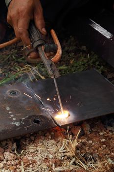 worker use electric welding for cutting hole and drill metal plate