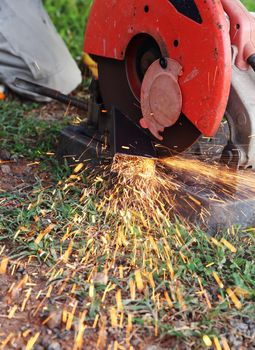 Worker cutting metal and spark with cutting machine