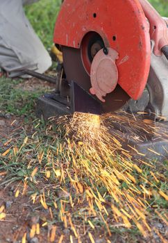 Worker cutting metal with cutting machine