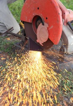 Worker cutting metal and spark with cutting machine