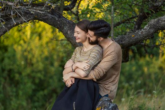 young couple hugging near a tree