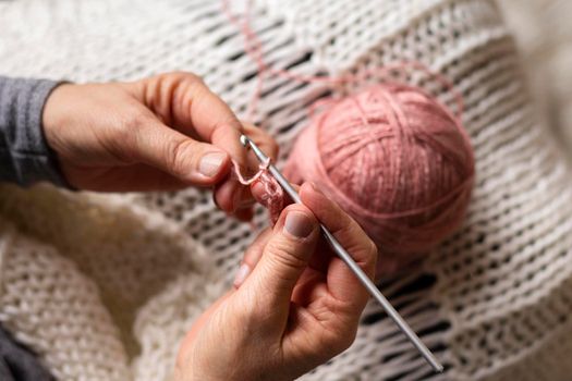 high view person knitting with pink thread