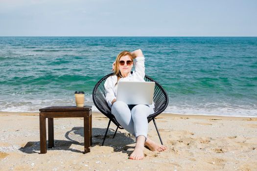 front view woman with laptop working beach with cup coffee